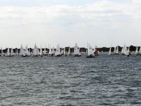 Photograph of small sailing dinghies racing just off shore